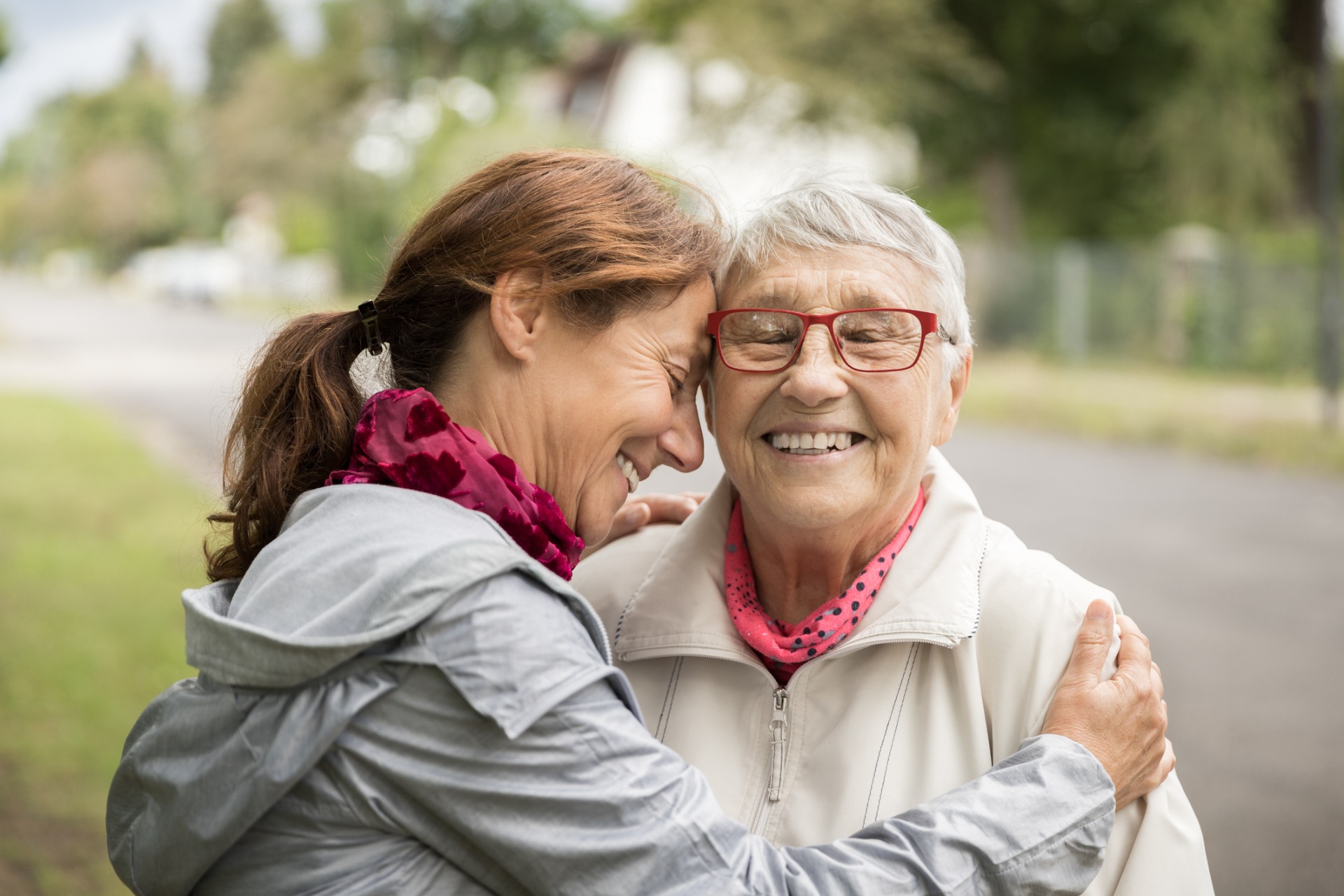 Two women of different generations laughing together on a walk outdoors