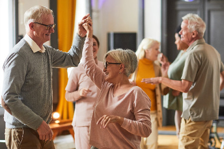 Older people dancing together at a community club