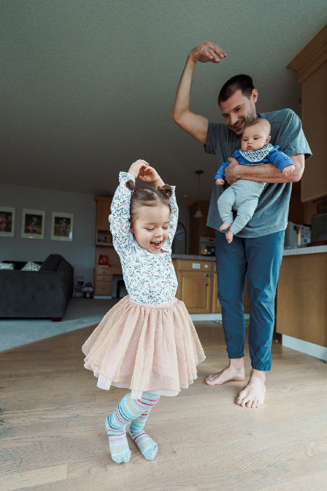 A parent and children dancing at home